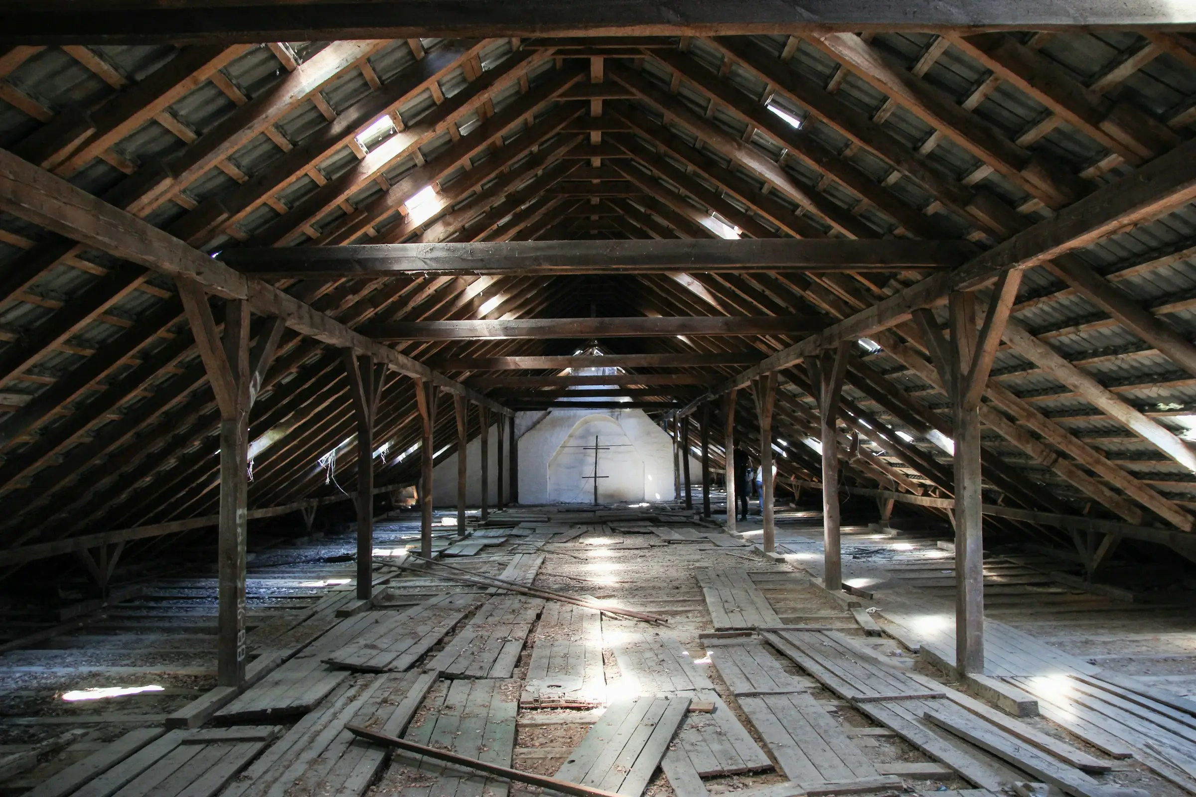 An unfinished wooden attic under a pitched roof